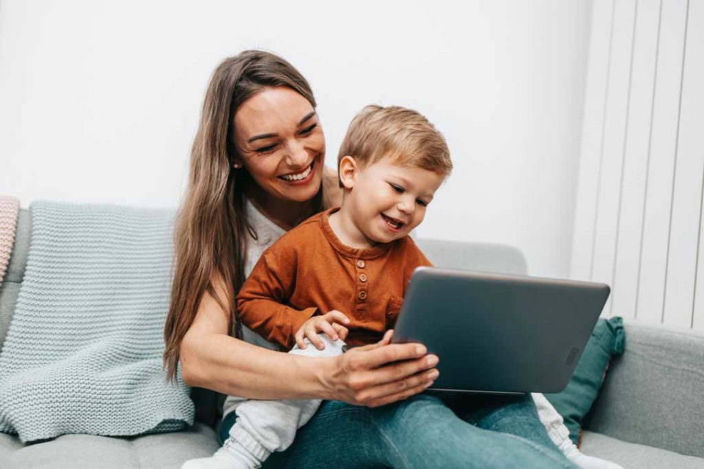 Happy Middle Age Woman Playing With Her Little Son At Home. They